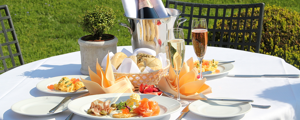 Schloss Wackerbarth Elegant gedeckter Frühstückstisch auf Schloss Wackerbarth mit Sekt, frischen Brötchen, Lachs, Eierspeisen und festlich gefalteten Servietten.